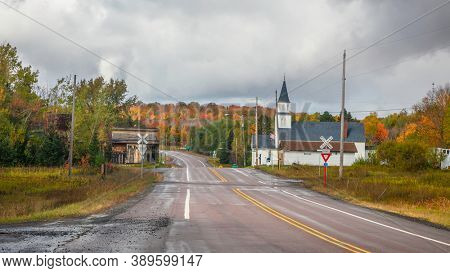Covington, MI - OCTOBER 01,2020:  Old church by rail road crossing in small town Covington in Michigan upper peninsula.