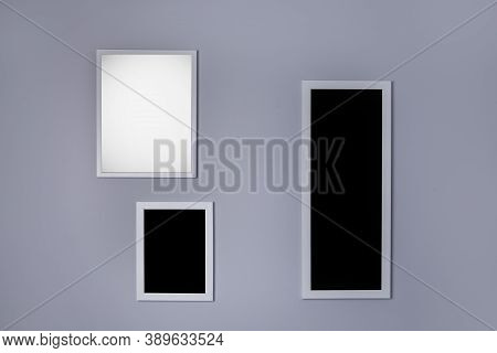 Poster Mockup With Three Frames On Empty Grey Wall