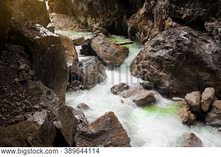 Fast River In Mountain Gorge. Large Stones On Banks. Partnachklamm, Famous Tourist Destination. Part