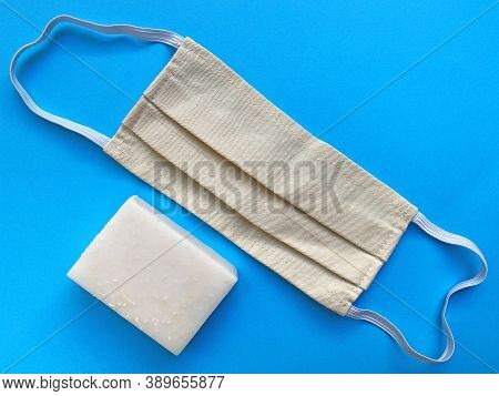 White Hand Soap And Surgical Face Mask On A Blue Backround