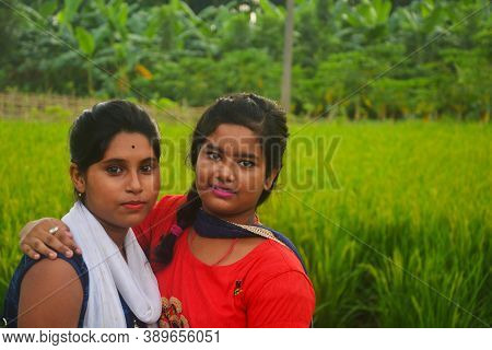 Close  Of  Two  Teenage Girls Wearing Colorful Indian Dresses Of Salwar Kameez In A Green Paddy Fiel