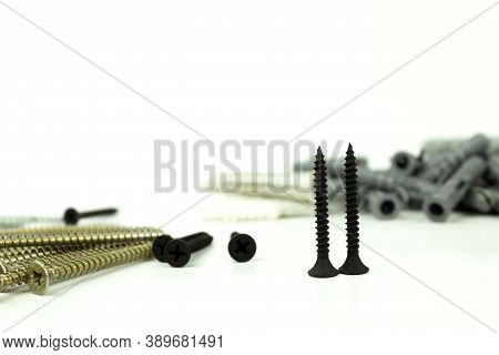 Construction Screws And Dowels On An Isolated White Background. Old Screws And Dowels Are In A Row. 