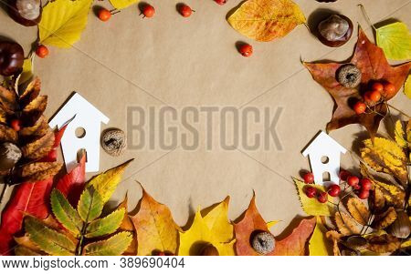 Autumn Composition. White Decorative Houses With Autumn Leaves, Chestnuts, Rowan, Acorns On A Beige 