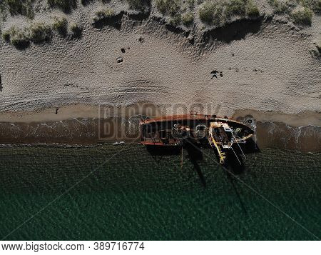 A Ship Lying On Board On A Sandy Beach After A Storm