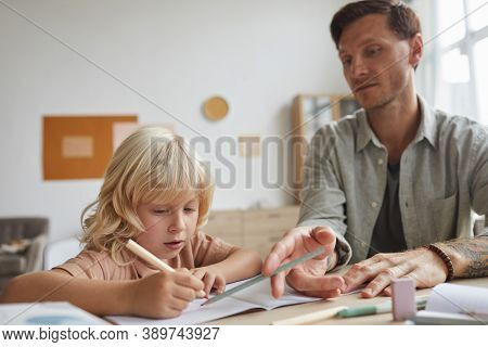 Teacher Sitting At The Table With His Pupil And Explaining Hime The New Topic