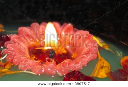 Rosso galleggianti candela sull'acqua verde
