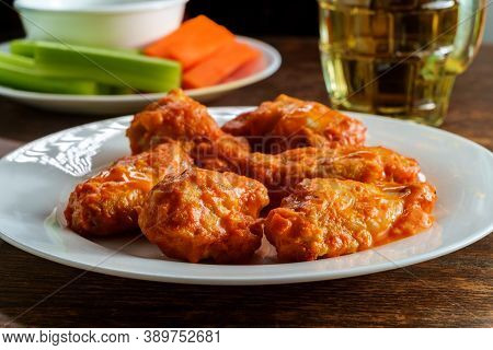 Bar Or Pub Food Spicy Buffalo Wings And Beer With Sliced Carrot Sticks Celery And Blue Cheese Dressi