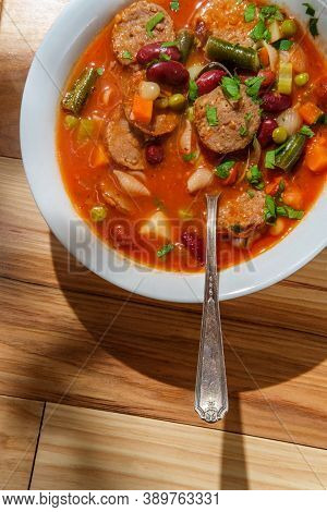 Hearty Italian Minestrone Soup With Sliced Sausage And Vegetables