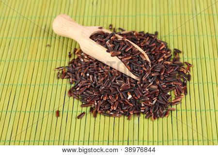 arroz preto com colher de madeira em esteira de bambu