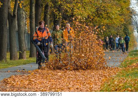 Moscow. Russia. October 11, 2020: A Female Utility Worker Uses A Blower To Remove Fallen Leaves In A