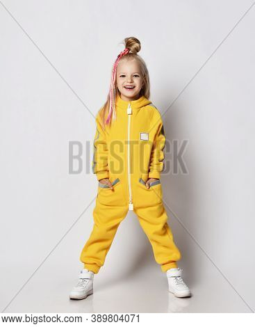 Cheerful Laughing Blonde Kid Baby Girl With Girlish Hairstyle And Colorful Braids In Stylish Yellow 