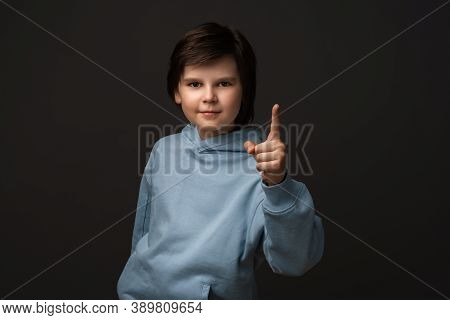 Portrait Of Serious Boy 10-12 Years Old In Casual Clothes Showing Index Finger, Scolding Or Telling 