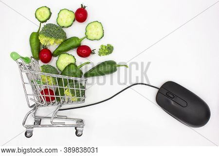Mini Shopping Cart Or Trolley Full Of Vegetables Next To A Computer Mouse On White Background. Healt