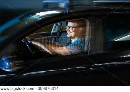 Handsome young driver driving hic car fast yet safely on the road