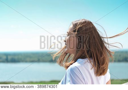Beautiful Woman With Messy Hair Blown By Wind Looking At Landscape. Riverside Country Tranquil Place