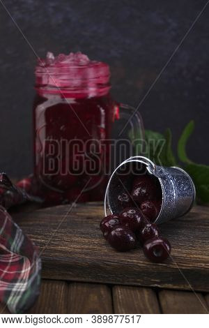 A Small Aluminum Bucket With Fresh Organic Red Cherry Fruits Scattered On A Wooden Old Textured Boar