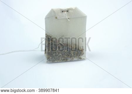 White Dry Tea Bag On A Gray Background. One Rectangular Tea Bag Closeup. Herbal And Black Tea Bags.