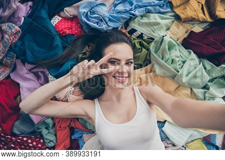 High Angle Above Photo Of Lovely Funny Lady Home Spring Cleaning Lying Many Clothes Stack Floor Prep