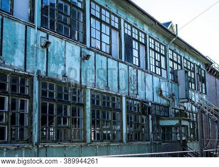 Industrial Weathered Urban Building With Rusting Window Grill And Discoloured Painted Wall Surface