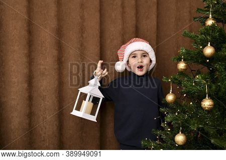 An Enthusiastic Child, Jumped Out From Behind The Christmas Tree With A Lantern.