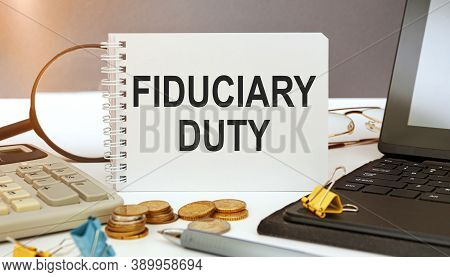 Desktop With Documents, Calculator And Notebook. On A Blockboard Inscription Fiduciary Duty