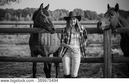 American Woman On A Horse Farm. Portrait Of Girl In Cowboy Hat With A Horses. Hippotherapy At Nature