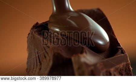 Detail of piece of chocolate with pouring hot chcocolate on top. Studio macro shot.