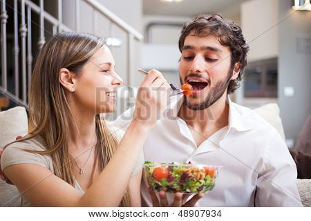 いくつかのリビング ルームで、サラダを食べる