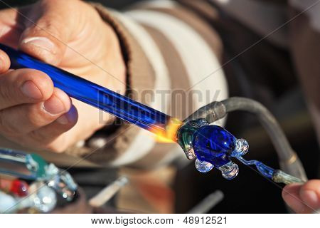 Heikle Arbeit des Gebläses Glas. Auf einem Foto sind die Hände des Meisters sichtbar. Der Künstler-Glas-Schlag