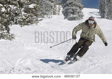 雪に覆われた斜面をスキー若者の完全な長さ