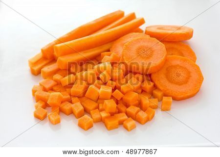 Carrots sliced and diced on white surface