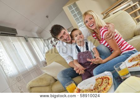 happy young family eating tasty pizza with cheesa and dring healthy and fresh orange juice
