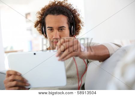 Smiling man listening to music with tablet
