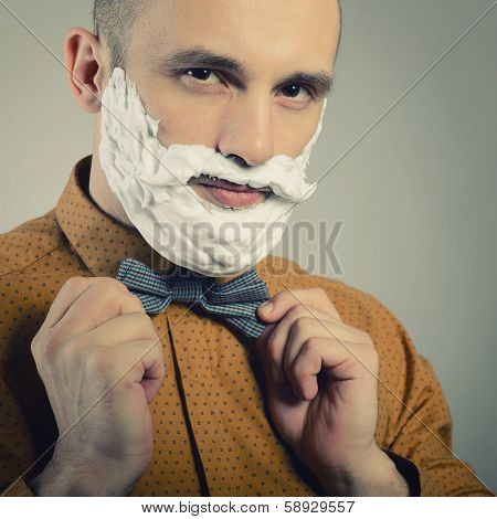 Hipster. Funny portrait of trendy man with moustache and beard of shaving foam, toned.
