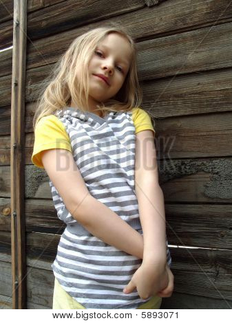 La petite fille contre un mur en bois