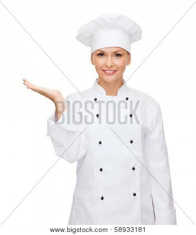 cooking, advertisement and food concept - smiling female chef, cook or baker holding something on palm of hand