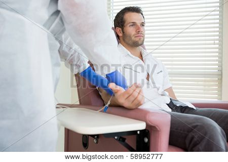 Young male patient receiving intravenous treatment in chemo room
