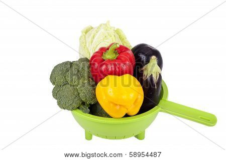 Fresh Vegetables In Plastic Colander Over White