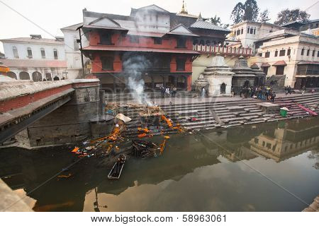 KATHMANDU, NEPAL - DEC 20: During the cremation ceremony along the holy Bagmati River in Bhasmeshvar Ghat at Pashupatinath temple, Dec 20, 2013 in Kathmandu, Nepal.