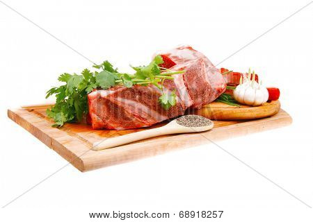 butchery : fresh raw beef lamb big rib and fillet ready to cooking with green stuff on wooden plate isolated over white background