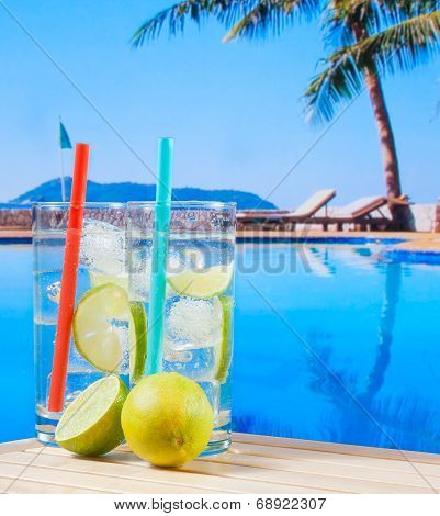 Two Glasses Of Cocktail With Lime Slice Near Swimming Pool