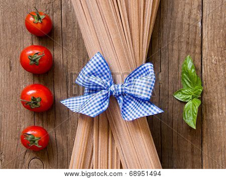 Pasta, Tomatoes And Basil On Wooden Background
