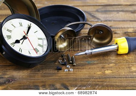 Repair clock on wooden background