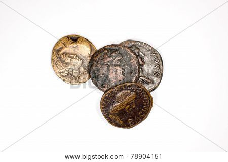 Four Old Coins With Portraits Of Emperors On A White Background