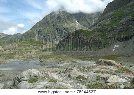 Rocks In Valley Nearby Glacier In Alps In Switzerland