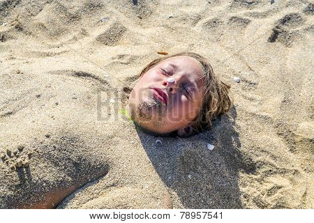Young Girl Is Covered By Sand At The Beach