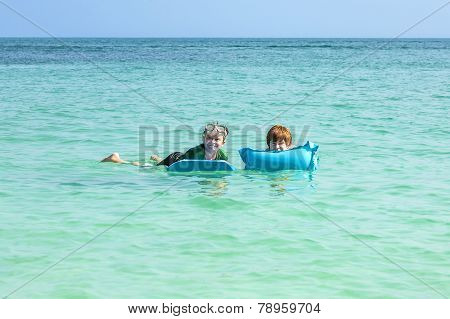 Boys Swim In The Ocean With Air Matress And Have Fun