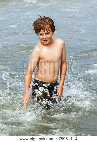 Boy Enjoys The Waves In The Ocean