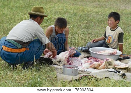 Mongolian men cut mutton meat, Harhorin, Mongolia.