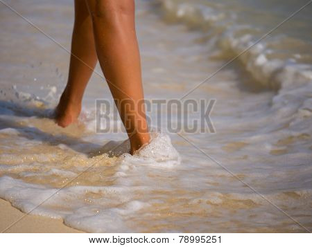 Woman walking on the sandy beach - Selective focus